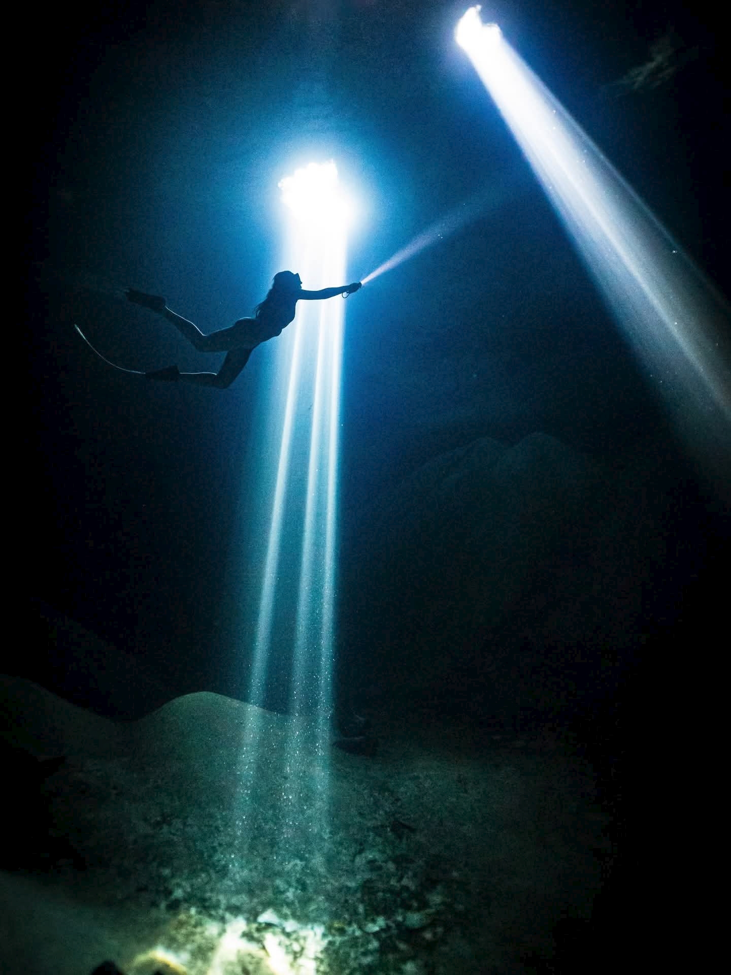 Exploración submarina con linterna en el cenote